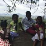 Kinder in Sri Lanka sitzen auf einem Felsen