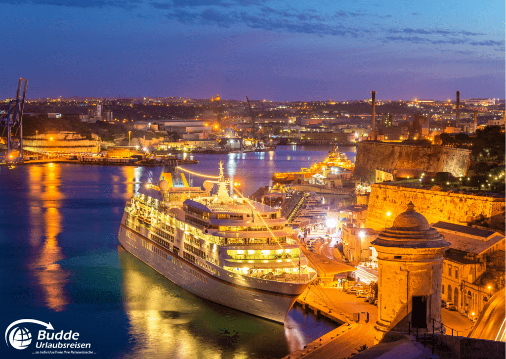 Ein beleuchtetes Kreuzfahrtschiff liegt bei Nacht im Hafen von Valletta, Malta.