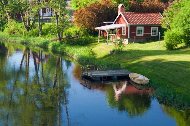 Schweden-Idyll-Ferienhaus Das bezaubernde Bild zeigt ein idyllisches Ferienhaus in Schweden, umgeben von malerischer Natur. Das charmante Holzhaus strahlt eine warme und einladende Atmosphäre aus, während es von üppigem Grün und blühenden Blumen umgeben ist. Die umliegende Landschaft bietet eine Oase der Ruhe und lädt zu erholsamen Spaziergängen in der Natur ein. Dieses Ferienhaus ist der perfekte Ort, um dem Alltagsstress zu entfliehen und die entspannte schwedische Lebensart zu genießen. Tauchen Sie ein in das Schweden-Idyll und lassen Sie sich von der Schönheit dieser Landschaft verzaubern.