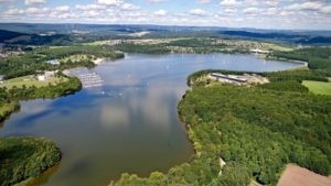 Bostalsee Hafen Luftperspektive Willkommen am bezaubernden Bostalsee Hafen, den Sie auf diesem Bild aus der Luftperspektive bewundern können! Buchen Sie bei uns Touren durchs Nahetal und entdecken Sie die Schönheit des Bostalsees. Erleben Sie eine unvergessliche Bootsfahrt entlang des Sees, erkunden Sie die malerische Umgebung und genießen Sie die herrliche Aussicht. Erleben Sie unvergessliche Momente, während Sie den Bostalsee Hafen aus der Vogelperspektive betrachten und die entspannte Atmosphäre des Nahetals genießen.