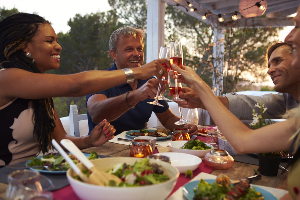 Ferienhaus mit Freunden buchen Verbringen Sie unvergessliche Abende mit Ihren Freunden in einem gemütlichen Ferienhaus! Das Bild zeigt eine fröhliche Gruppe von Freunden, wie sie das gemeinsame Abendessen auf der Terrasse ihres Ferienhauses genießen. Entfliehen Sie dem Alltag und erleben Sie unbeschwerte Momente in einem komfortablen und gut ausgestatteten Ferienhaus. Genießen Sie die Geselligkeit beim Grillen, kochen Sie gemeinsam in der voll ausgestatteten Küche und lassen Sie den Tag bei einem Glas Wein ausklingen. In unseren Ferienhäusern finden Sie den perfekten Raum, um Zeit mit Ihren Freunden zu verbringen, gemeinsame Erinnerungen zu schaffen und sich rundum wohlzufühlen. Buchen Sie jetzt Ihr Ferienhaus und freuen Sie sich auf unvergessliche Abende mit Ihren Liebsten!