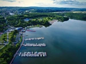 Bostalsee Hafen Willkommen zum idyllischen Bostalsee Hafen, den Sie auf diesem Bild bewundern können! Buchen Sie bei uns Touren durchs Nahetal und entdecken Sie die faszinierende Schönheit dieses malerischen Hafens. Der Bostalsee bietet zahlreiche Freizeitmöglichkeiten wie Wassersport, Bootsfahrten und Entspannung am Ufer. Erkunden Sie die herrliche Umgebung, genießen Sie den Blick auf den glitzernden See und lassen Sie sich von der natürlichen Ruhe und Gelassenheit des Ortes verzaubern. Der Bostalsee Hafen lädt Sie ein, unvergessliche Momente zu erleben und das Nahetal aus einer neuen Perspektive zu entdecken.