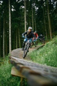 Nahe-Stromberg-Flowtrail-Mountainbike Willkommen zum aufregenden Flowtrail in Stromberg, den Sie auf diesem Bild mit einer begeisterten Gruppe von Fahrradfahrern in Aktion bewundern können! Buchen Sie bei uns Touren durchs Nahetal und erleben Sie den Nervenkitzel dieses erstklassigen Mountainbike-Trails. Der Flowtrail in Stromberg bietet Ihnen eine spannende Strecke mit zahlreichen Sprüngen, Anliegern und Wellen, die perfekt auf den Flow abgestimmt sind. Beobachten Sie die Fahrer, wie sie mit Geschwindigkeit und Können den Trail hinunterrasen und die Herausforderungen des Geländes meistern. Erleben Sie unvergessliche Momente, während Sie die Gruppe von Fahrradfahrern auf dem Flowtrail in Stromberg betrachten und den Adrenalinschub des Mountainbiking im Nahetal spüren.