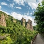 Weinbauregion Nahe-Fahrradfahren an der Nahe-Landkreis Bad Kreuznach Willkommen zu einem beeindruckenden Anblick des Rheingrafensteins entlang des Fahrradwegs an der malerischen Nahe! Das Bild zeigt den majestätischen Rheingrafenstein, der sich stolz über dem Fluss erhebt, während Radfahrer die idyllische Landschaft der Nahe erkunden. Buchen Sie bei uns Touren entlang der Nahe und erleben Sie die faszinierende Kombination aus Fahrradfahren und Natur. Der Fahrradweg entlang der Nahe bietet Ihnen nicht nur die Möglichkeit, die herrliche Aussicht auf den Rheingrafenstein zu genießen, sondern auch die Schönheit der umliegenden Weinberge und malerischen Ortschaften zu entdecken. Erleben Sie unvergessliche Momente, während Sie das Bild der Radfahrer am Rheingrafenstein betrachten und die harmonische Verbindung von Aktivität, Natur und Entspannung im Herzen des Nahetals spüren.