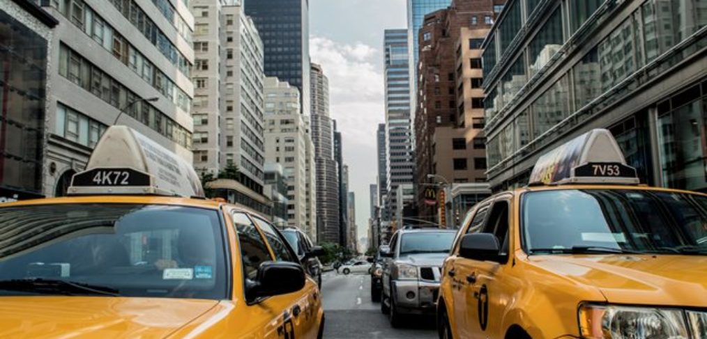New York-Urlaubsreise USA-Taxi im Verkehr Das Bild zeigt die pulsierende Metropole New York City in den USA, wo der Verkehr von gelben Taxis dominiert wird. Die Straßen sind belebt und voller Energie, während die gelben Taxis geschäftig durch die Straßen von Manhattan fahren. Dieses Bild fängt die lebendige Atmosphäre und das typische Stadtbild von New York ein, das für seine ikonischen gelben Taxis bekannt ist. Ein Urlaub in New York bietet eine Fülle an Sehenswürdigkeiten, Kultur und aufregenden Erlebnissen.