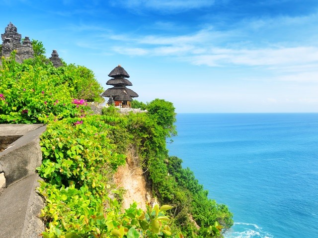 Uluwatu tempel-Urlaubsreise Bali-Urlaubsangebote Indonesien Das Bild zeigt den beeindruckenden Uluwatu-Tempel auf Bali, Indonesien, der ein beliebtes Reiseziel für Urlauber aus aller Welt ist. Der Tempel thront majestätisch auf einer Klippe über dem Indischen Ozean und bietet einen atemberaubenden Panoramablick. Tauchen Sie ein in die spirituelle Atmosphäre dieses heiligen Ortes, erkunden Sie die kunstvollen Tempelstrukturen und erleben Sie den Zauber der balinesischen Kultur. Bali ist bekannt für seine tropische Schönheit und den entspannten Lebensstil, und der Uluwatu-Tempel verkörpert all das in Perfektion.