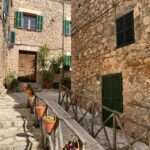 Gasse mit Steinmauern und Blumentöpfen in Valldemossa