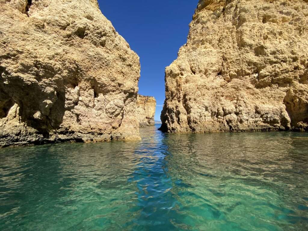 Vor der malerischen Kulisse der Küste mit den Grotten an der Algarve in Portugal wird die bedeutungsvolle Natur des Reisens deutlich. Die majestätischen Felsformationen und versteckten Höhlen symbolisieren die unendlichen Entdeckungsmöglichkeiten, die das Reisen bietet. Ein inspirierendes Bild, das uns daran erinnert, wie wichtig es ist, die Welt zu erkunden und neue Abenteuer zu erleben.