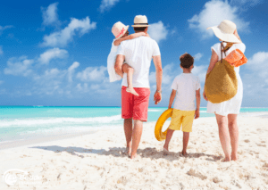 Familie am Strand bei ihrer Urlaubsreisen, die zum Wasser schaut