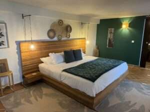 Ein stilvolles Schlafzimmer mit Holzbett und moderner Dekoration in einem Adults-Only und LGBTQ-freundlichen Boutique-Hotel.