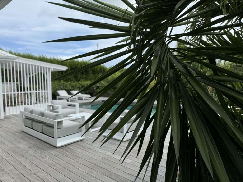 Moderne Poolterrasse mit Palmen im Pomme Cannelle