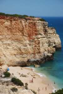 Eine kleine, versteckte Bucht mit goldenen Sandstränden und türkisfarbenem Wasser an der Algarve.
