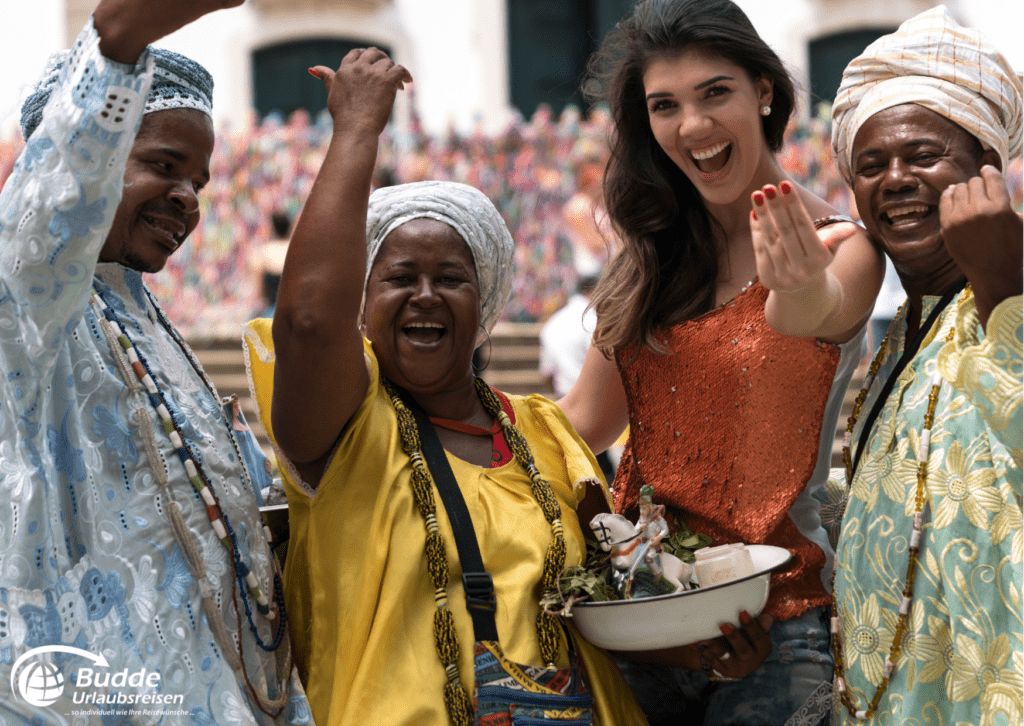 Das ist nachhaltiges Reisen. Eine Gruppe von Menschen in traditioneller Kleidung feiert gemeinsam.