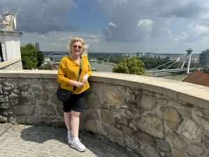 Anke Budde, Reisebüroinhaberin von Budde Urlaubsreisen, posiert vor der Bratislava Burg mit Blick auf die Stadt.