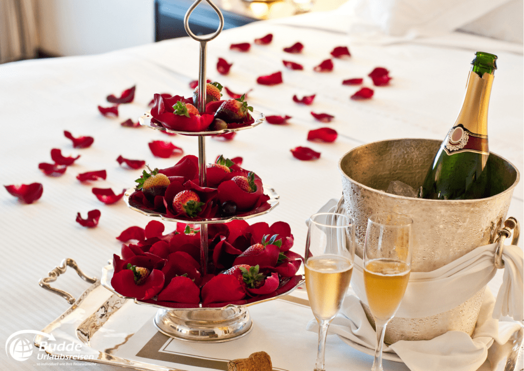Romantische Frühstückstafel mit Rosenblättern und Champagner während der Flitterwochen auf Saint Martin.