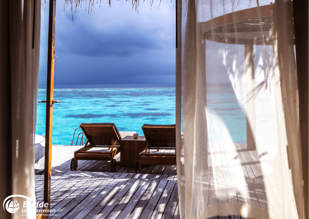 Flitterwochen Saint Martin - Blick aus einem Strandbungalow auf das türkisblaue Meer. Reisen nach Saint Martin buchbar bei Budde Urlaubsreisen.