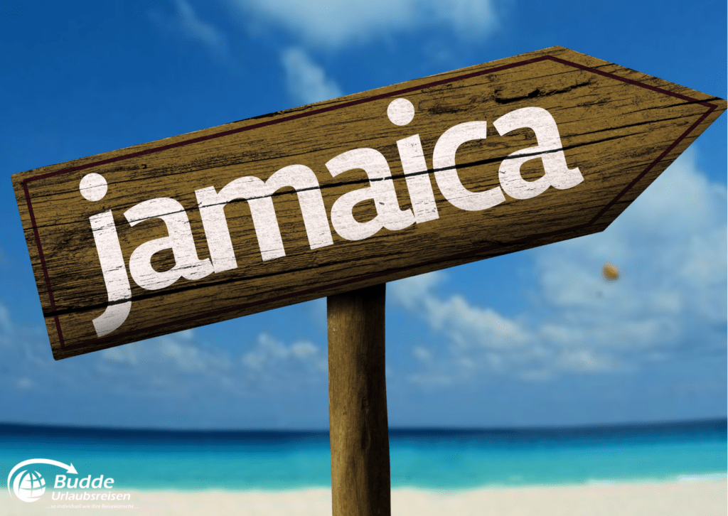 Urlaubsreisen Holzschild mit der Aufschrift 'jamaica' vor einem blauen Himmel und Meer.