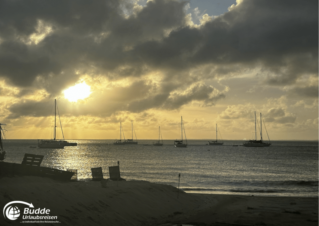 Reiseerfahrungen Saint Martin - Sonnenuntergang am Strand mit Segelbooten.