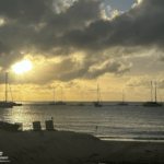 Reiseerfahrungen Saint Martin - Sonnenuntergang am Strand mit Segelbooten.