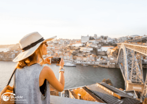 Eine Frau fotografiert die Stadt Porto in Portugal von einem Aussichtspunkt aus, eine großartige Möglichkeit für eine Reise gegen Einsamkeit.