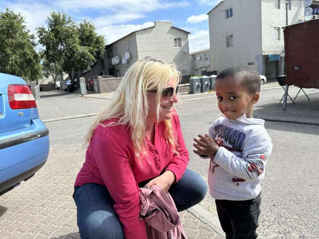 World Tourism Day 2024 - Frau interagiert mit einem Kind in einer Nachbarschaft in Kapstadt, Südafrika.