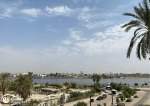 Ägypten Urlaub: Panoramablick auf den Nil mit Palmen und Gebäuden am Ufer in Hurghada, Ägypten. - buchbar im Reisebüro Budde Urlaubseisen