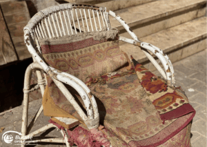Ägypten Urlaub: Abgenutzter Korbstuhl mit einem Teppichüberwurf, der auf der Sitzfläche liegt. - buchbar im Reisebüro Budde Urlaubseisen