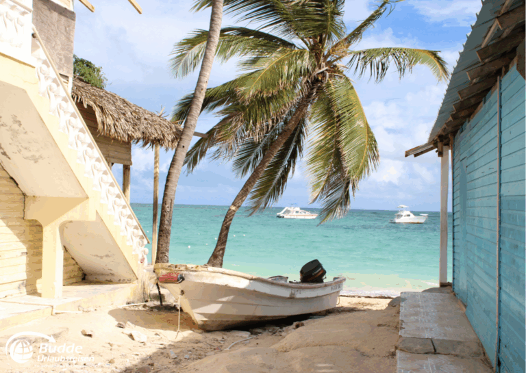 Liebesurlaub Dominikanische Republik – Fischerboot zwischen Palmen am Strand.
