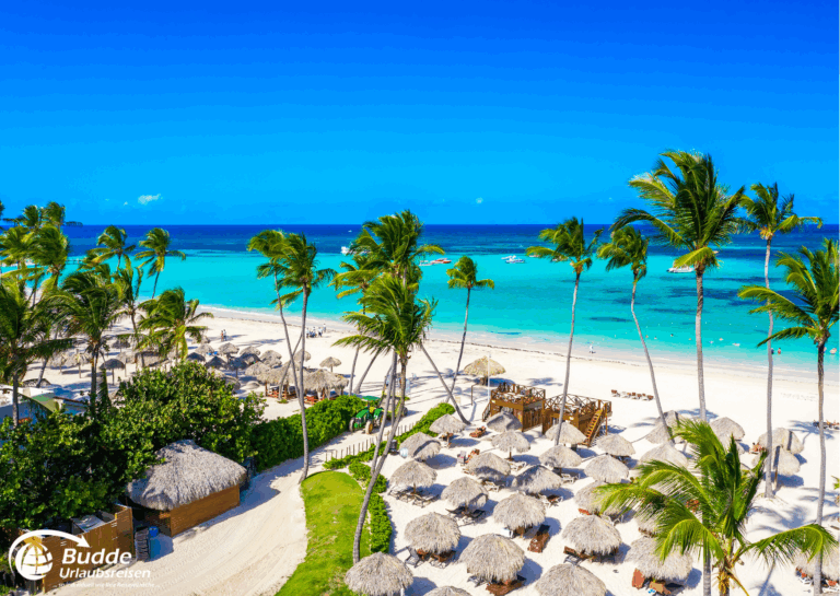 Exklusive Hotel für Paare Dominikanische Republik – palmengesäumter Strand mit Sonnenliegen.