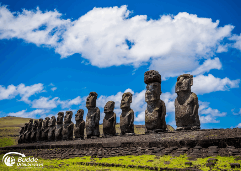 einzigartige Reiseerlebnisse weltweit: Reihe von Moai-Statuen auf der Osterinsel, einige mit Hüten aus rotem Vulkangestein. - buchbar im Reisebüro Budde Urlaubseisen