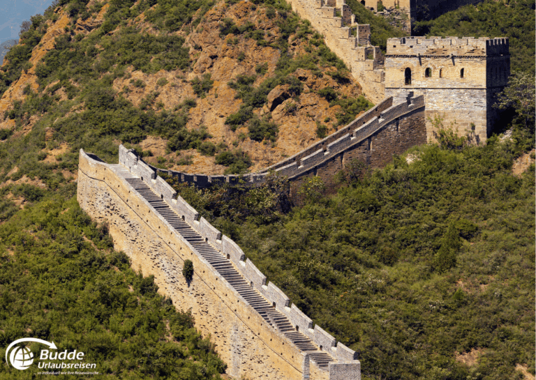 einzigartige Reiseerlebnisse weltweit: Ansicht der Chinesischen Mauer, die sich über einen Hügel mit Treppen und Mauern erstreckt. - buchbar im Reisebüro Budde Urlaubseisen