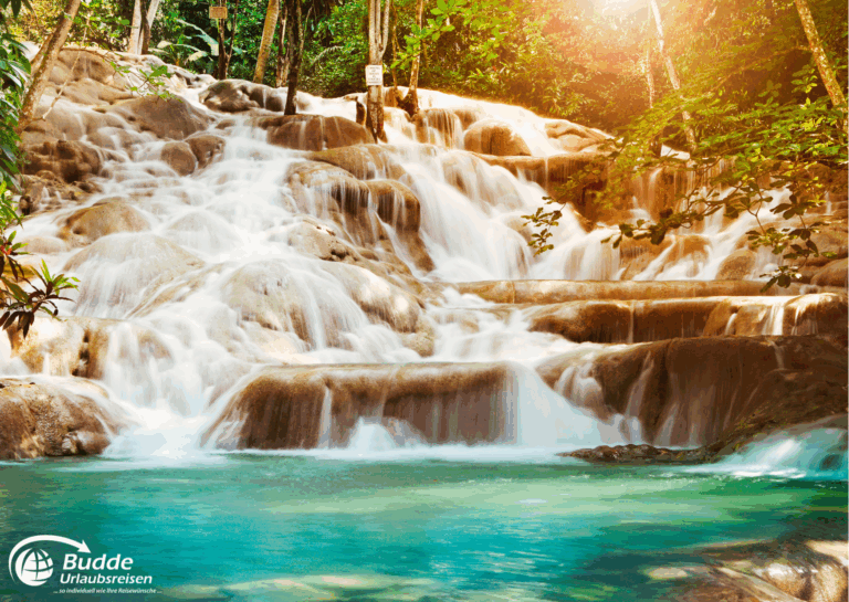 Jamaika Urlaub: Ein Wasserfall mit mehreren Stufen und klarem Wasser in einem tropischen Wald in Jamaika. - buchbar im Reisebüro Budde Urlaubseisen