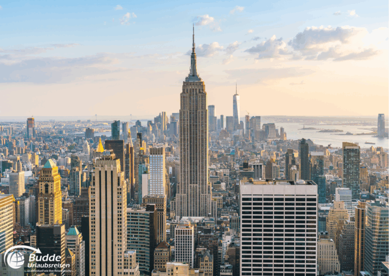 Blick auf die Skyline von New York mit dem Empire State Building im Vordergrund und anderen Wolkenkratzern. - Dein Luxusurlaub buchbar im Reisebüro Budde Urlaubseisen