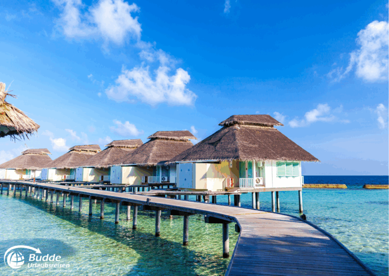 Reihe von Überwasser-Bungalows mit Strohdächern auf den Malediven, umgeben von klarem Wasser. - buchbar im Reisebüro Budde Urlaubseisen