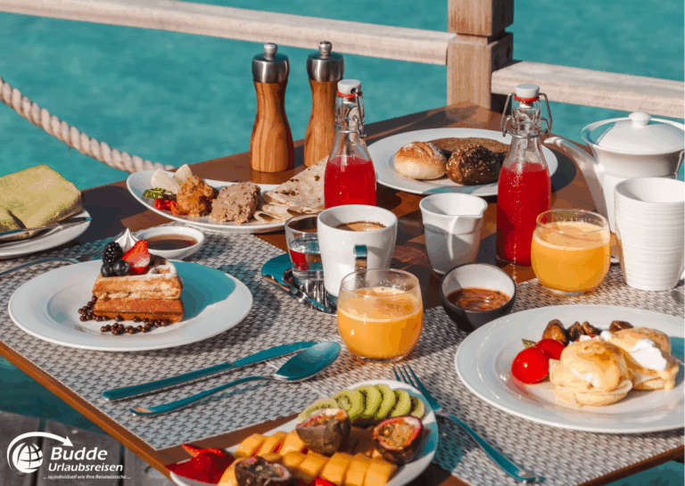 Ein Frühstückstisch mit einer Auswahl an Speisen und Getränken, darunter Obst, Gebäck und Getränke. - buchbar im Reisebüro Budde Urlaubseisen