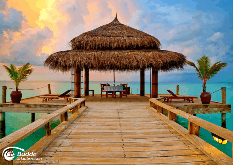 Holzpier mit Strohdach und Tisch, umgeben von Wasser im Malediven-Resort. - buchbar im Reisebüro Budde Urlaubseisen