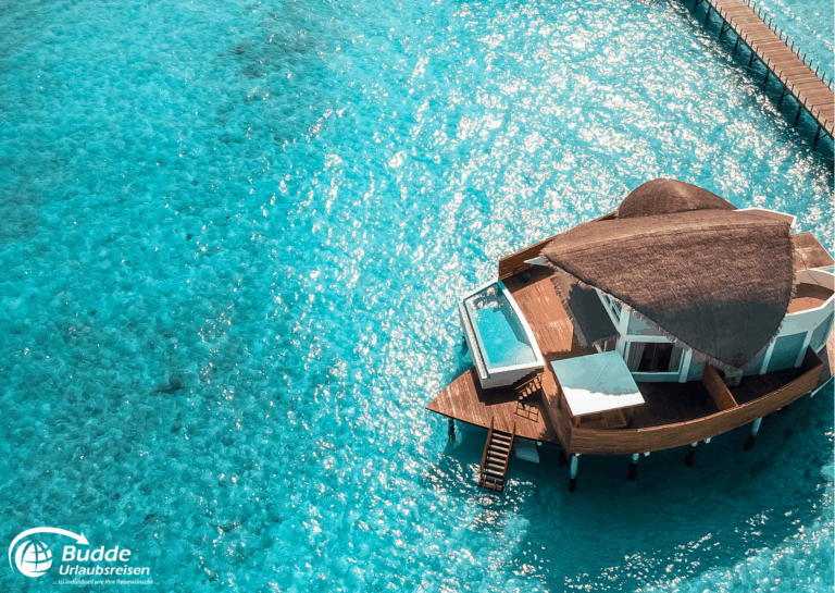 Ein Überwasser-Bungalow mit Pool auf blauen Gewässern der Malediven, umgeben von klarem Wasser. - buchbar im Reisebüro Budde Urlaubseisen