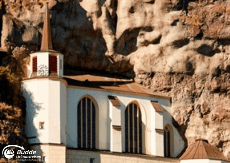 Urlaub Bad Kreuznach: Felsenkirche in Idar-Oberstein, eine Kirche, die in einen Felsen gebaut ist, mit einem spitzen Turm und großen Fenstern. - buchbar im Reisebüro Budde Urlaubseisen