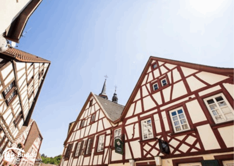 Urlaub Bad Kreuznach: Fachwerkhäuser mit sichtbarem Holzrahmen unter klarem Himmel in Meisenheim. - buchbar im Reisebüro Budde Urlaubseisen