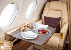 Romantikurlaub zu Zweit: Ein Tischgedeck mit verschiedenen Speisen und Getränken in einem Privatjet. - buchbar im Reisebüro Budde Urlaubseisen