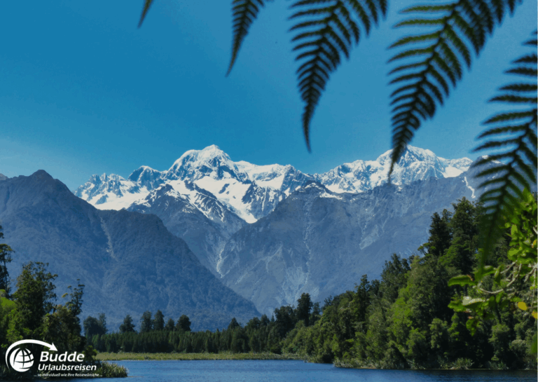 Rundreisen buchen: Schneebedeckte Berge in Neuseeland mit einem klaren blauen Himmel im Hintergrund. - buchbar im Reisebüro Budde Urlaubseisen