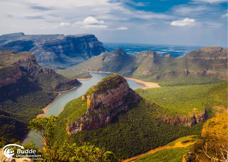 Rundreisen buchen: Panoramablick auf den Blyde River Canyon mit grünen Hügeln und einem Fluss im Vordergrund. - buchbar im Reisebüro Budde Urlaubseisen