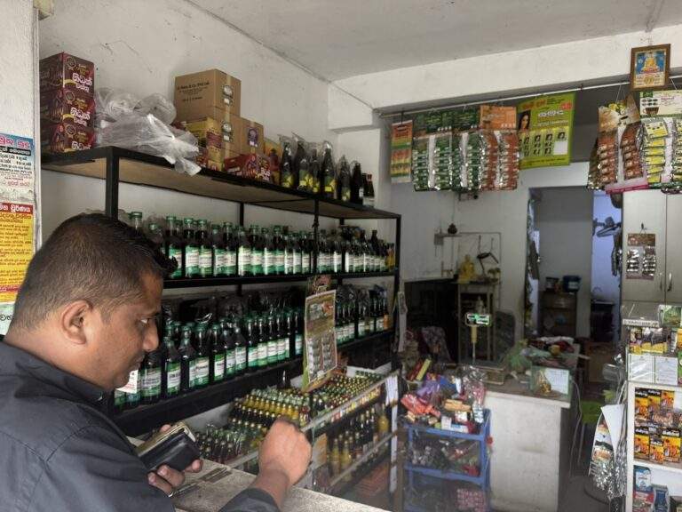 Sri Lanka Urlaub buchen: Ein Mann steht an einem Ladentresen in einem Geschäft mit Regalen voller Flaschen und Produkten. - buchbar im Reisebüro Budde Urlaubseisen