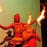 Zwei Männer in traditioneller Kleidung führen eine Feuerakrobatik-Nummer auf der Bühne durch. - Sri Lanka Urlaub buchen