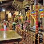 Innenansicht eines Tempels in Sri Lanka mit dekorativen Elementen und Blumenarrangements. - Sri Lanka Urlaub buchen