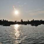 Sonnenuntergang über einem Gewässer mit mehreren Booten und Palmen im Hintergrund. - Sri Lanka Urlaub buchen