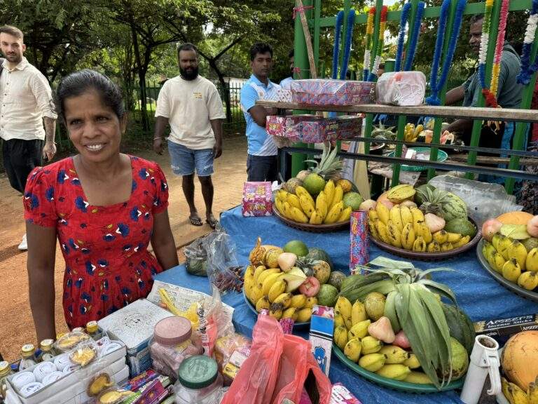 Sri Lanka Urlaub buchen: Frau an einem Obststand mit einer Vielzahl von frischen Früchten in Sri Lanka. - buchbar im Reisebüro Budde Urlaubseisen