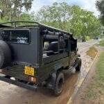 Nationalpark Elefanten Safari: Schwarzes Safari-Fahrzeug mit offener Rückbank auf einer Straße in der Natur. - buchbar im Reisebüro Budde Urlaubseisen