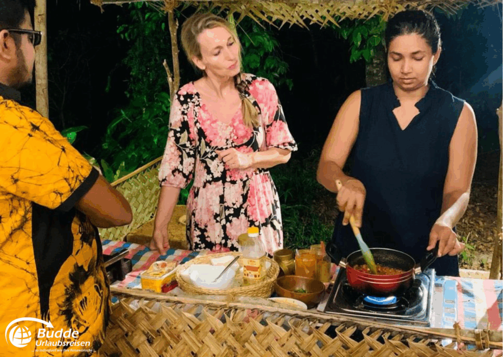 Praana Ayurvedic Boutique Hotel: Eine Frau rührt in einem Topf, während eine andere Frau zuschaut in einer Freiluftküche. - buchbar im Reisebüro Budde Urlaubseisen
