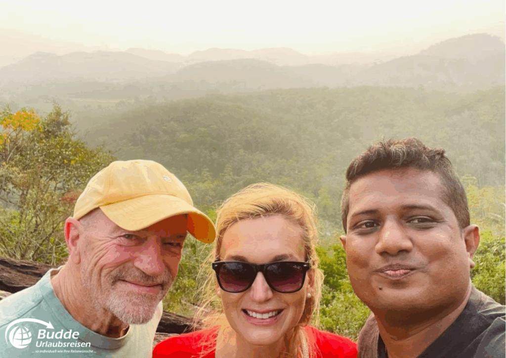 Drei Personen posieren für ein Foto vor einer bewaldeten Landschaft mit Hügeln im Hintergrund. - buchbar im Reisebüro Budde Urlaubseisen